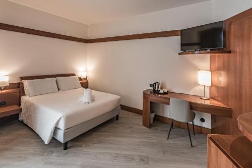 a bedroom with a bed and a desk and a television at BB Hotels Smarthotel Re Milano Nord in Sesto San Giovanni