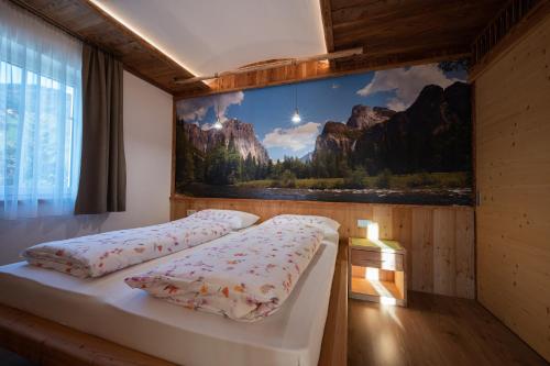 two beds in a room with a painting on the wall at Residence Treyer in Terento