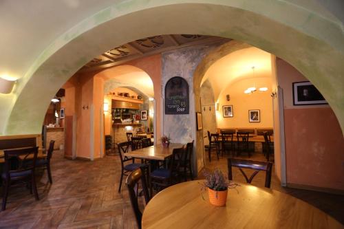 a restaurant with tables and chairs and an archway at U Cervene zidle - Red Chair Hotel in Prague
