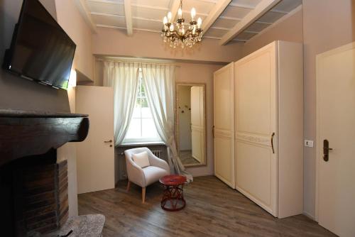 sala de estar con chimenea, silla y TV en Relais Villa Porta, en Luino