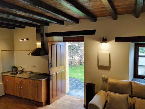 eine Küche mit Sofa und Waschbecken in einem Zimmer in der Unterkunft Casa Carballeira in Villarfernando