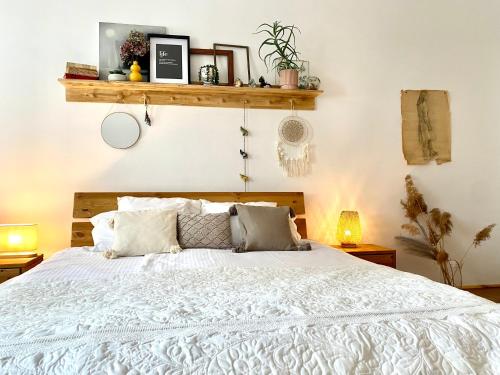 クルジュ・ナポカにあるCamino Homeのベッドルーム(白い大型ベッド、ランプ2つ付)