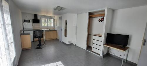 Il comprend un salon avec une télévision et une cuisine. dans l'établissement Studio 25, au Pradet