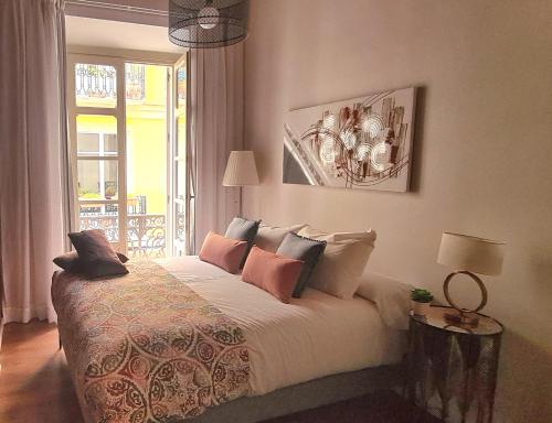 una camera da letto con letto, cuscini e finestra di Apartamento Viña P. Málaga Centro a Málaga