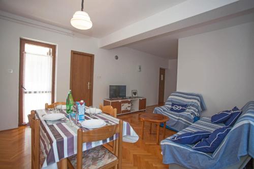 - un salon avec une table et un canapé dans l'établissement Apartments and Room Agata, à Banjole