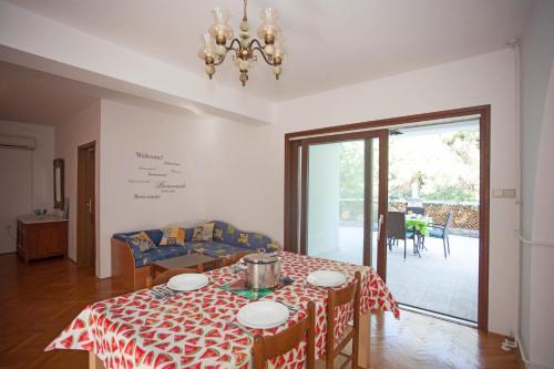 - une salle à manger avec une table et un pot dans l'établissement Apartments and Room Agata, à Banjole