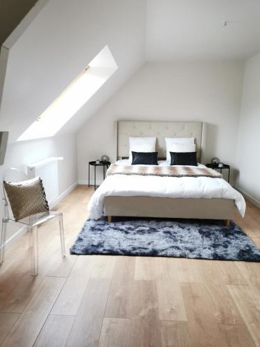 - une chambre avec un grand lit et un tapis bleu dans l'établissement Maison Design entre Paris, Deauville et Rouen, à Pont-de-lʼArche