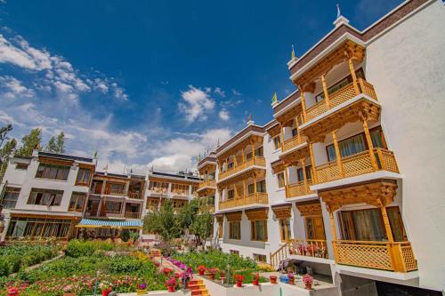 a group of buildings with flowers in a courtyard at Hotel Jigmet, Leh in Leh