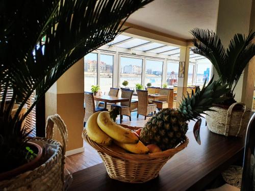 une corbeille de fruits sur une table avec un ananas dans l'établissement Pension Oderblick, à Francfort-sur-l'Oder