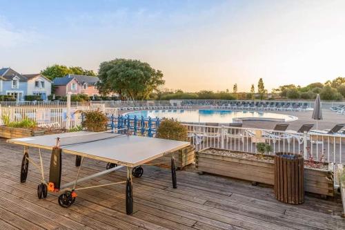 - une table de ping-pong sur une terrasse à côté de la piscine dans l'établissement Maison pour 6 - Piscine - Port Bourgenay, à Saint-Hilaire-de-Talmont