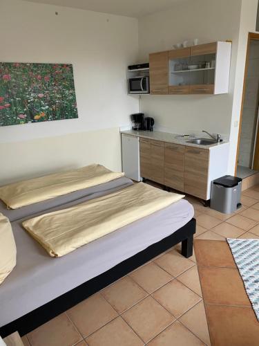 a room with two beds and a kitchen at Ferienwohnung Hummelhus Elmenhorst in Elmenhorst