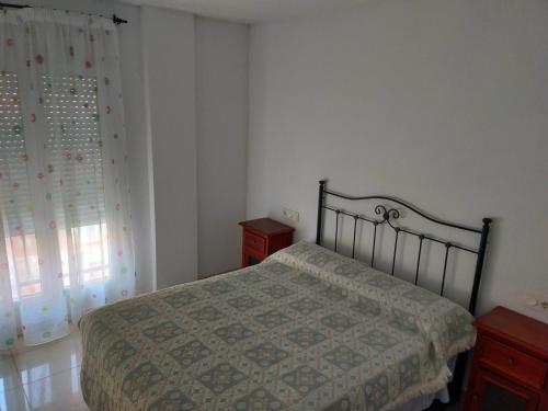 a bedroom with a bed and a window at Apartamento la romanilla a 200metros de la playa in Roquetas de Mar