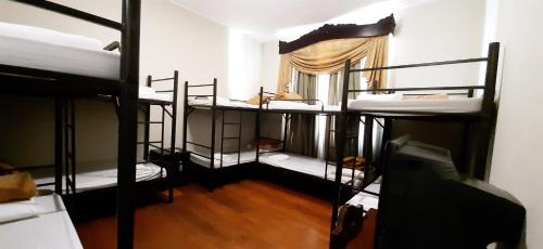 a room with four bunk beds and a window at Hotel Salcedo De Vigan in Vigan