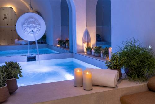 een groot zwembad met twee kaarsen en een bad met planten bij Hôtel Vinci Due & Spa in Parijs
