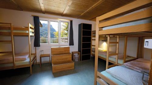 una camera con diversi letti a castello e una finestra di Brienz Youth Hostel a Brienz