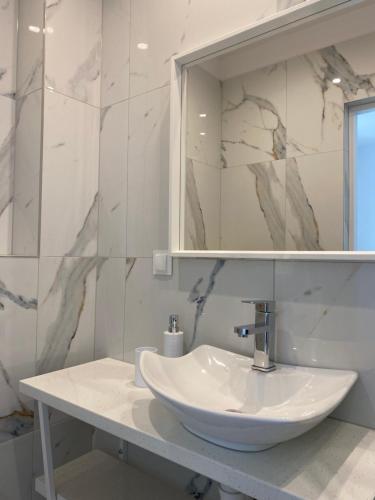a bathroom with a white sink and a mirror at Pokoje Gościnne Akwatel in Jastarnia