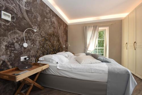 1 dormitorio con 1 cama y un mural en la pared en Relais Villa Porta en Luino