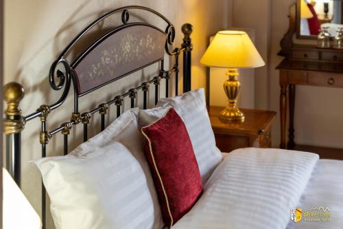 a bed with two pillows and a lamp on a table at Arkefthos Mountain Hotel in Papigko