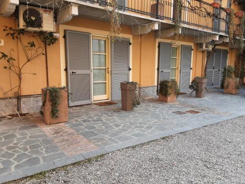 a building with doors and potted plants in front of it at Corte Delle Rose in Voghera