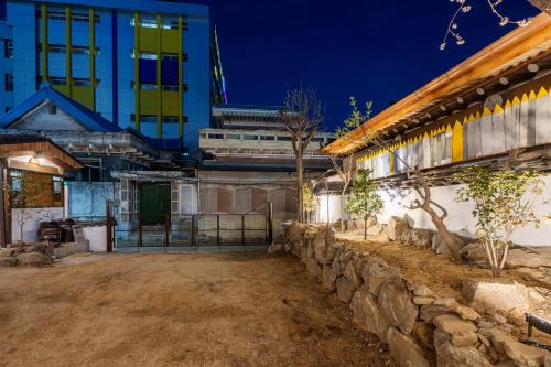 a building with a stone wall in front of a building at Aega Hanok Guesthouse in Daegu