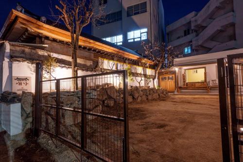a fence in front of a building at night at Aega Hanok Guesthouse in Daegu