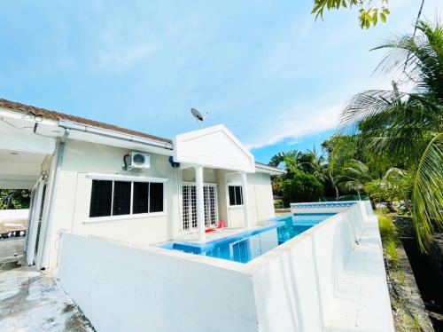 une maison blanche avec une piscine en face de celle-ci dans l'établissement Pd Villa Holiday, à Port Dickson