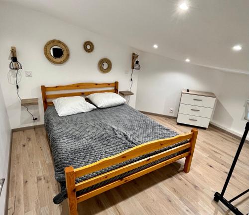 - une chambre avec un lit en bois et une commode dans l'établissement Maisonnette climatisée, à Saint-Jean-de-Monts