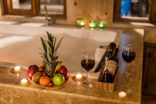 a bowl of fruit and two glasses of wine on a counter at Simera in Cappadocia - Special Class - Best View Rooftop in Uchisar