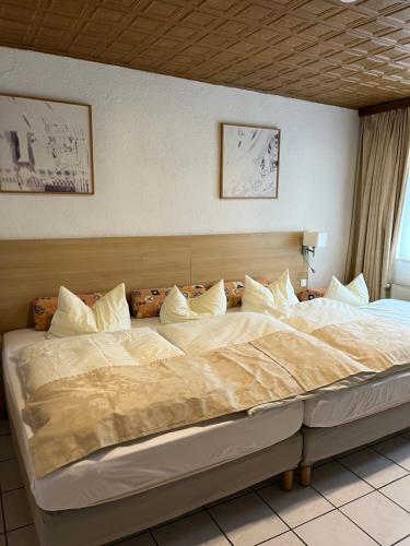 Elle comprend un grand lit avec des draps et des oreillers blancs. dans l'établissement Altes Gasthaus Leuna Pension, à Leuna