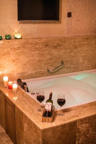 a tub with two glasses of wine and wine bottles at Simera in Cappadocia - Special Class - Best View Rooftop in Uchisar