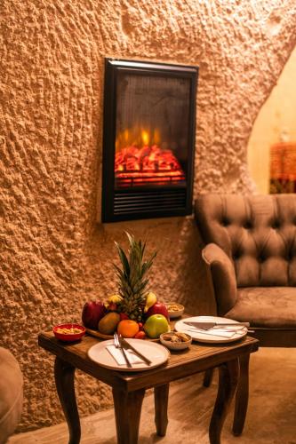 a fireplace in a living room with a table with fruit at Simera in Cappadocia - Special Class - Best View Rooftop in Uchisar