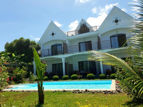 una casa con piscina frente a ella en Villa Malandy Appart Hôtel Duplex 1, en Ambatoloaka