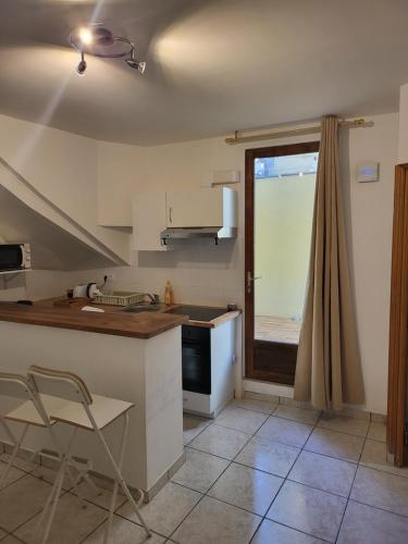 a kitchen with a counter and a table and a window at Paris Malakoff Garden Apartments in Malakoff
