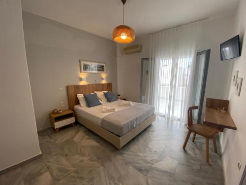 a bedroom with a bed and a table and a chair at Kostas & Joanna Studios in Logaras