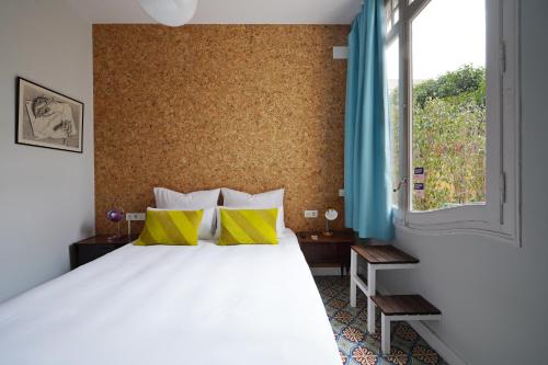 a bedroom with a large white bed with yellow pillows at numa l Roca Rooms & Apartments in Barcelona