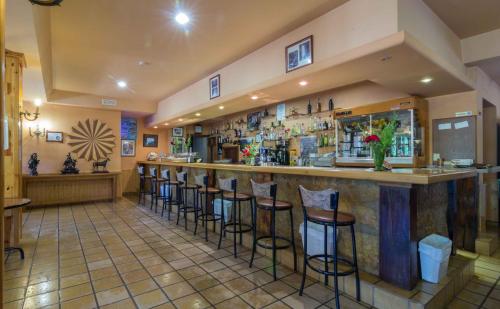 a bar in a restaurant with stools at Hotel Riopar Spa in Riópar