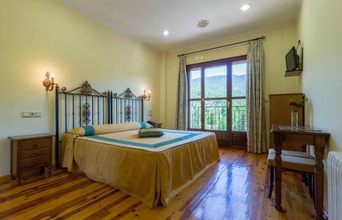 a bedroom with a large bed and a window at Hotel Riopar Spa in Riópar