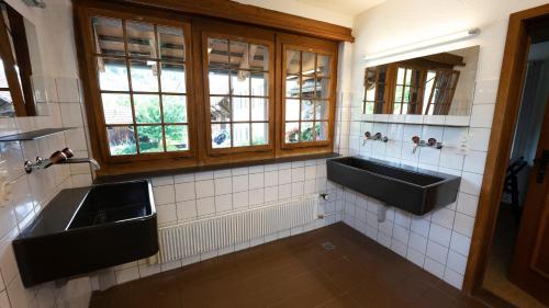 ein Badezimmer mit zwei Waschbecken und zwei Fenstern in der Unterkunft Brugg Youth Hostel in Brugg