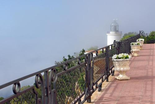 a wooden walkway with a lighthouse at El Far Hotel Restaurant in Llafranc