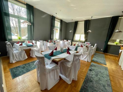 a room with white tables and chairs in it at Parkhotel Waldschlösschen in Annaberg-Buchholz