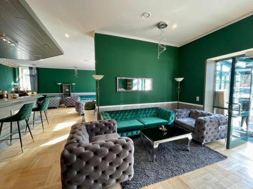 sala de estar con paredes verdes y sofá verde en Parkhotel Waldschlösschen, en Annaberg-Buchholz