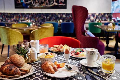 Me and All Hotel Dusseldorf Oberkassel, by Hyatt في دوسلدورف: طاولة مليئة بأطباق الطعام والخبز