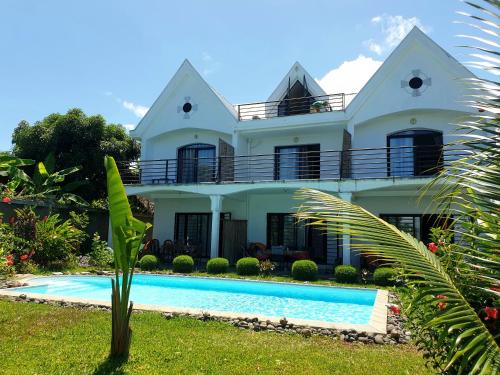 a house with a swimming pool in front of it at Villa Malandy Appart Hôtel Triplex in Madirokely