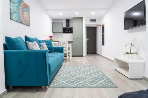 a living room with a blue couch and a kitchen at Sea View Apartments Olimp - Avenue Hotels in Olimp
