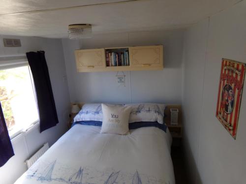 - une petite chambre avec un lit et une fenêtre dans l'établissement Happydaze Caravan, à Bacton