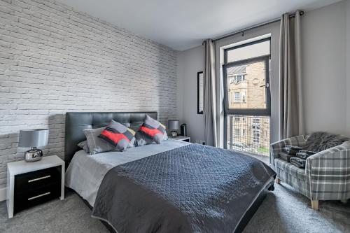ein Schlafzimmer mit einem Bett und einer Ziegelwand in der Unterkunft amazing apartments - Hopetoun Street near The Playhouse in Edinburgh