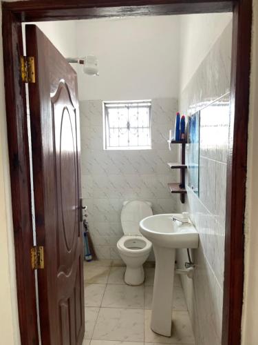 ein Bad mit einem WC und einem Waschbecken in der Unterkunft ANN AKAN NIDO’S in Malindi