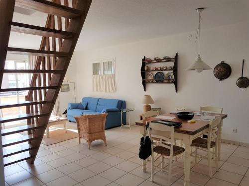 un salon avec une table et un canapé bleu dans l'établissement PALMERAIE 133, à Sari-Solenzara