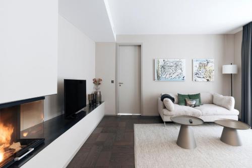 a living room with a couch and a fireplace at Andermatt Alpine Apartments in Andermatt