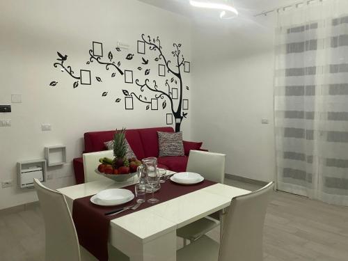 a dining room with a table and a tree with music notes at Le Case di Lory in Lecce